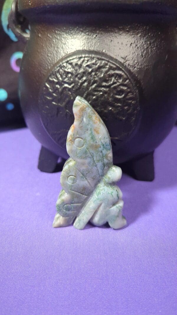 A small stone statue of a person with a bird on it.