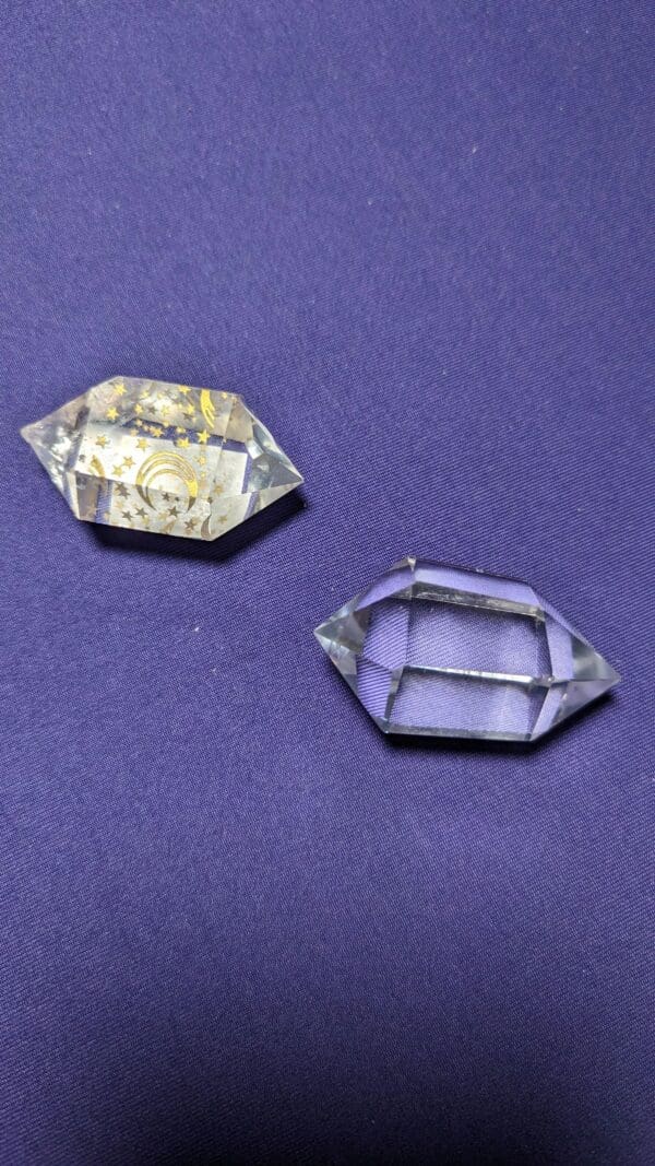 Two pieces of glass are sitting on a purple cloth.