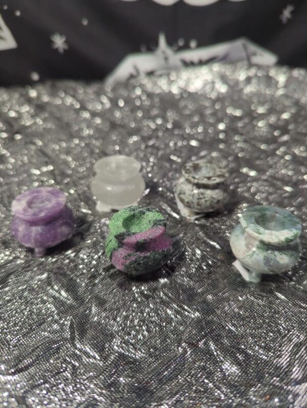 A group of four different colored rocks on top of a table.