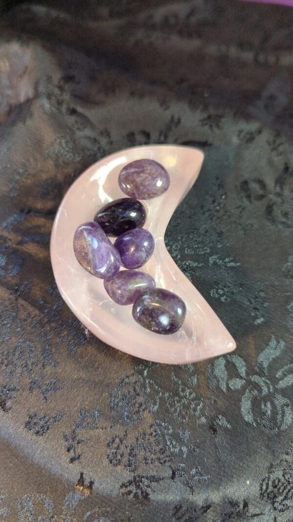 A bowl of purple and black rocks on a table.