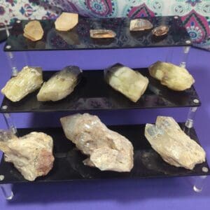 A display of various rocks and minerals on three shelves.