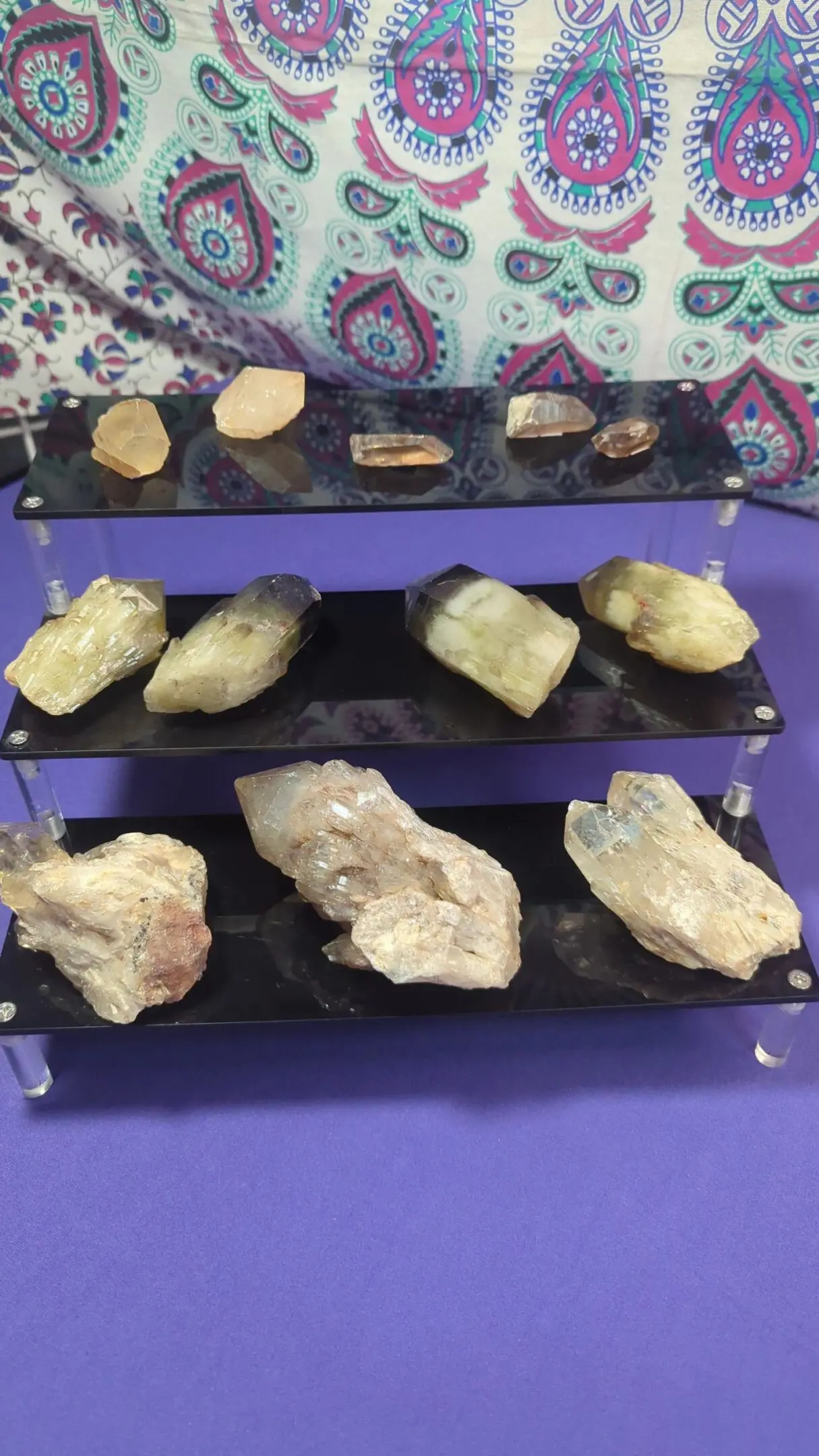 A display of various rocks and minerals on three shelves.