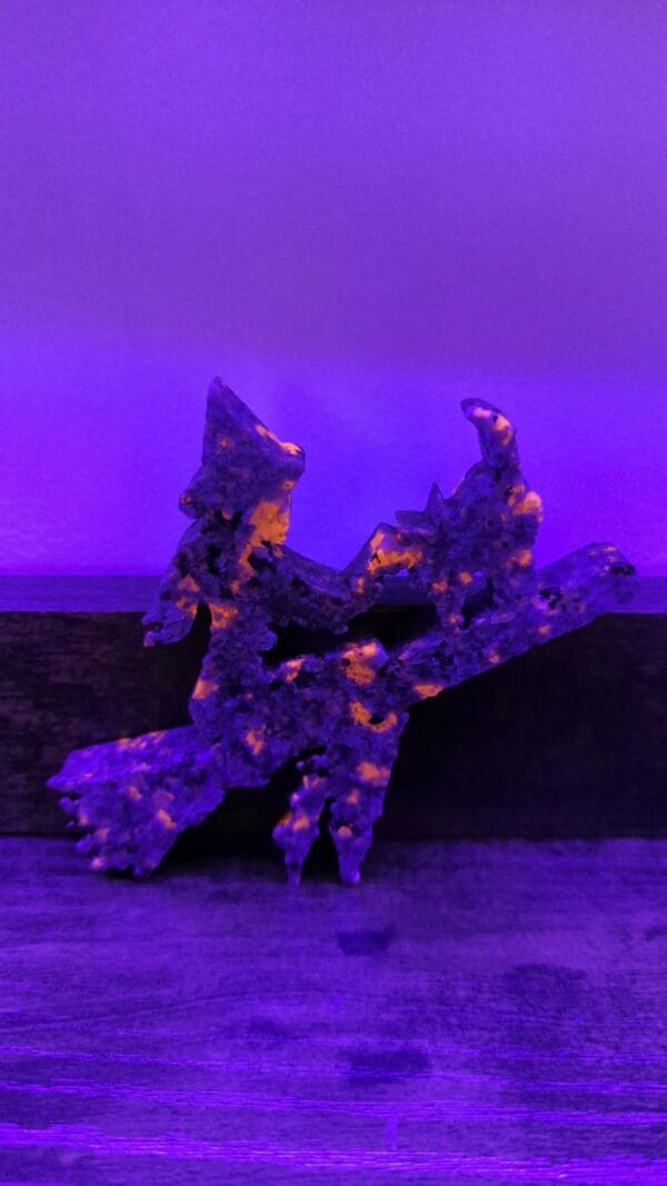 A purple sculpture of a witch on a broom.