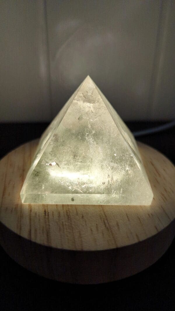 A glass pyramid sitting on top of a wooden table.