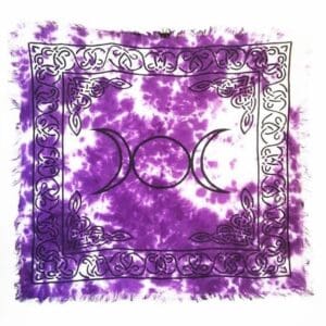 A purple tie dye altar cloth with the triple moon symbol.