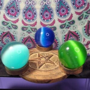 Three different colored balls on a wooden stand.