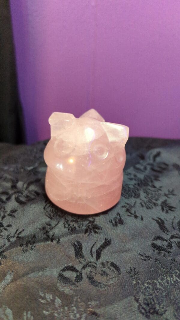 A pink cat candle holder sitting on top of a table.