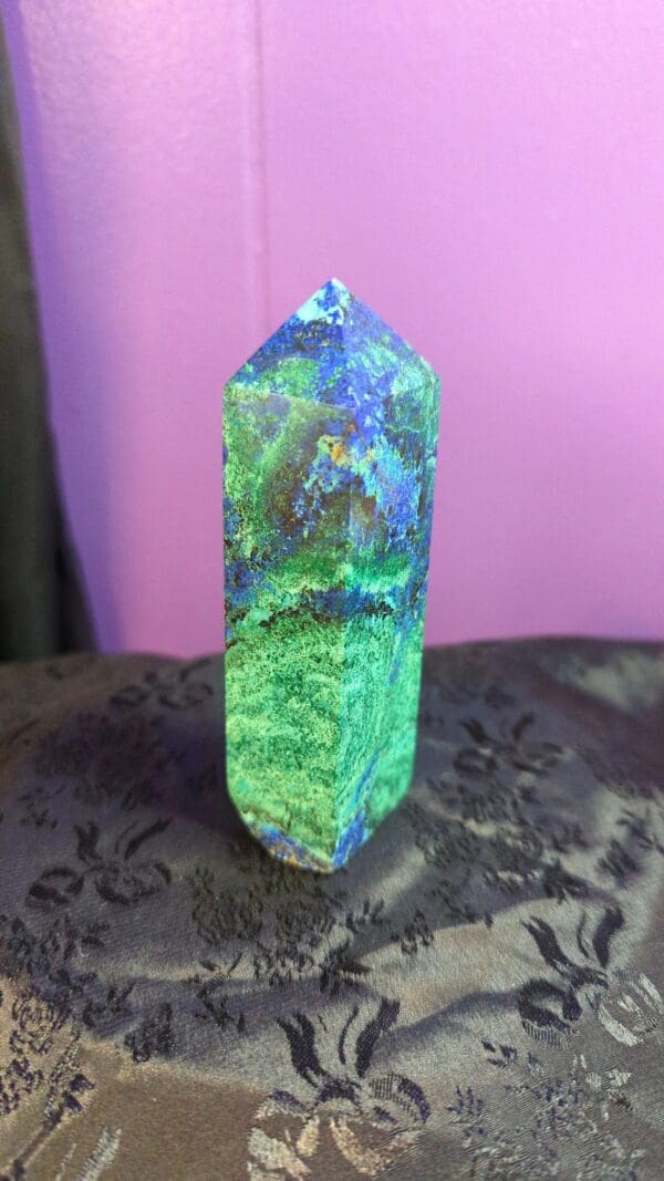 A green and blue stone sitting on top of a table.