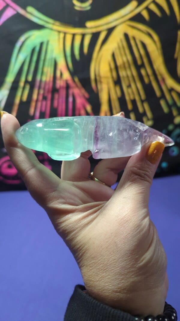 A person holding a large crystal in their hand.