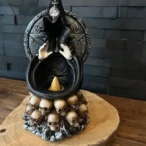 A statue of a witch with skulls on top.