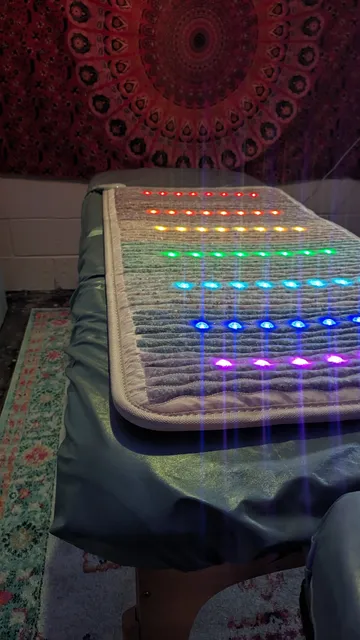 A bed with lights on it and a blue blanket