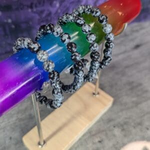 Colorful beaded rings displayed on a stand with a vibrant background.